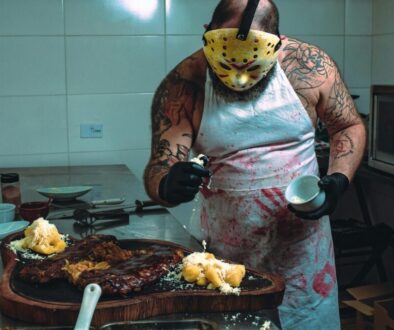 A chef in a dramatic mask and blood-stained apron prepares food in a kitchen, symbolizing sales presentation gone wrong and how to fix it.