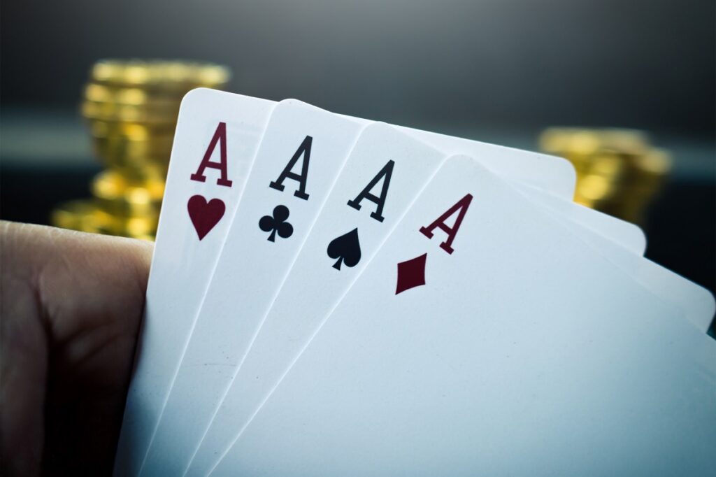 Four aces in a hand symbolizing a winning strategy for remote sales success.