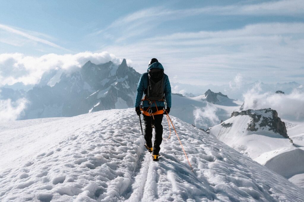 Solo climber on snowy mountain symbolizing the preparation needed for success in remote presentations.