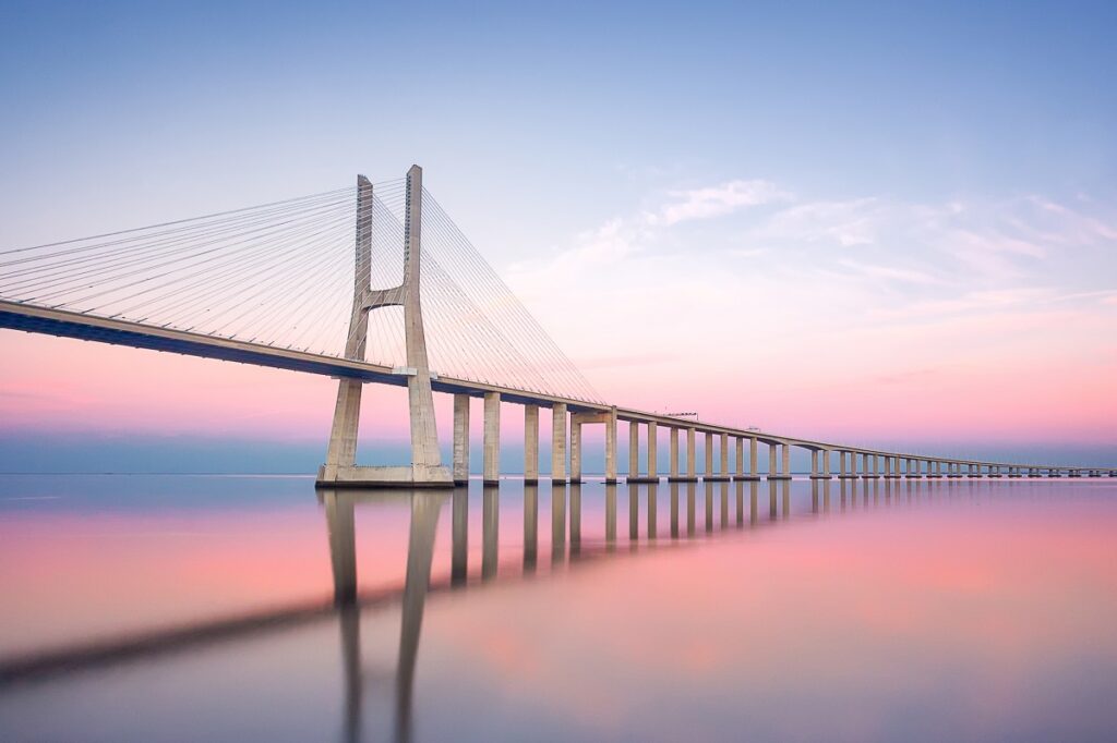 Modern bridge extending over calm waters symbolizing the strong foundation needed to make VC fund pitches stand out.